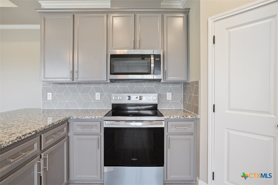 3824 Keller Road Temple, TX 76504 - Photo 10 of 28 a kitchen with granite countertop white cabinets and stainless steel appliances