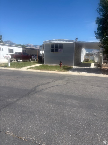 1111 North 2000 West, Unit 293 Farr West, UT 84404 - Photo 1 of 13 Single-story property featuring light gray vinyl siding and a metal roof