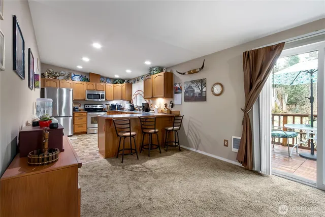 a living room with stainless steel appliances kitchen island granite countertop furniture and a view of kitchen