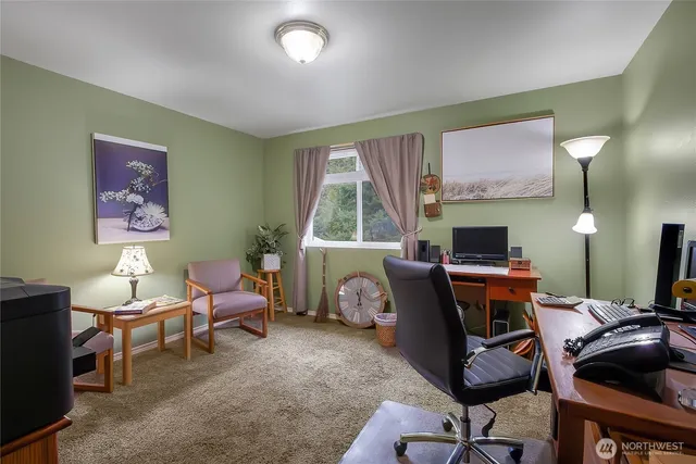 a view of a workspace with furniture and a window