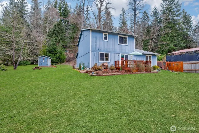 a front view of house with yard and trees in the background