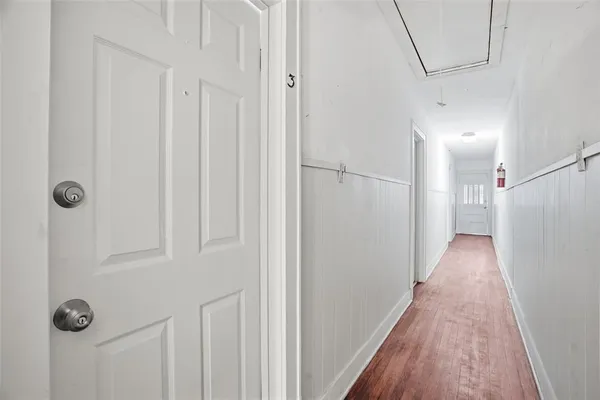 a view of a hallway with wooden floor