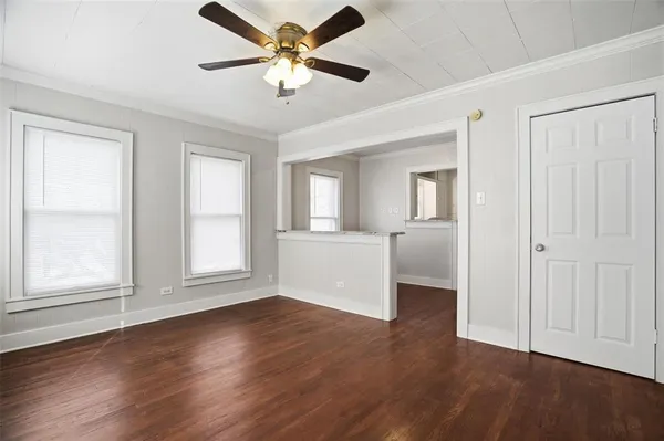 a view of an empty room with a window and wooden floor
