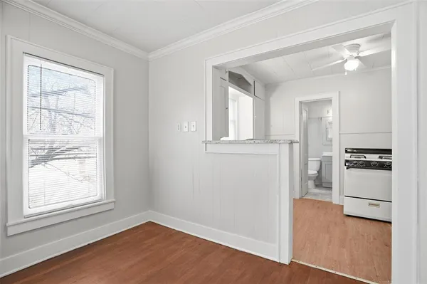 an empty room with windows and kitchen view