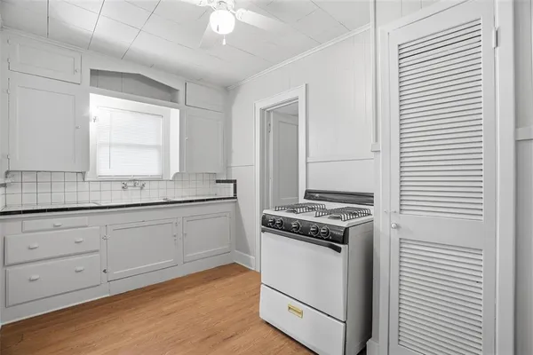 a kitchen with granite countertop cabinets stainless steel appliances and a wooden floor