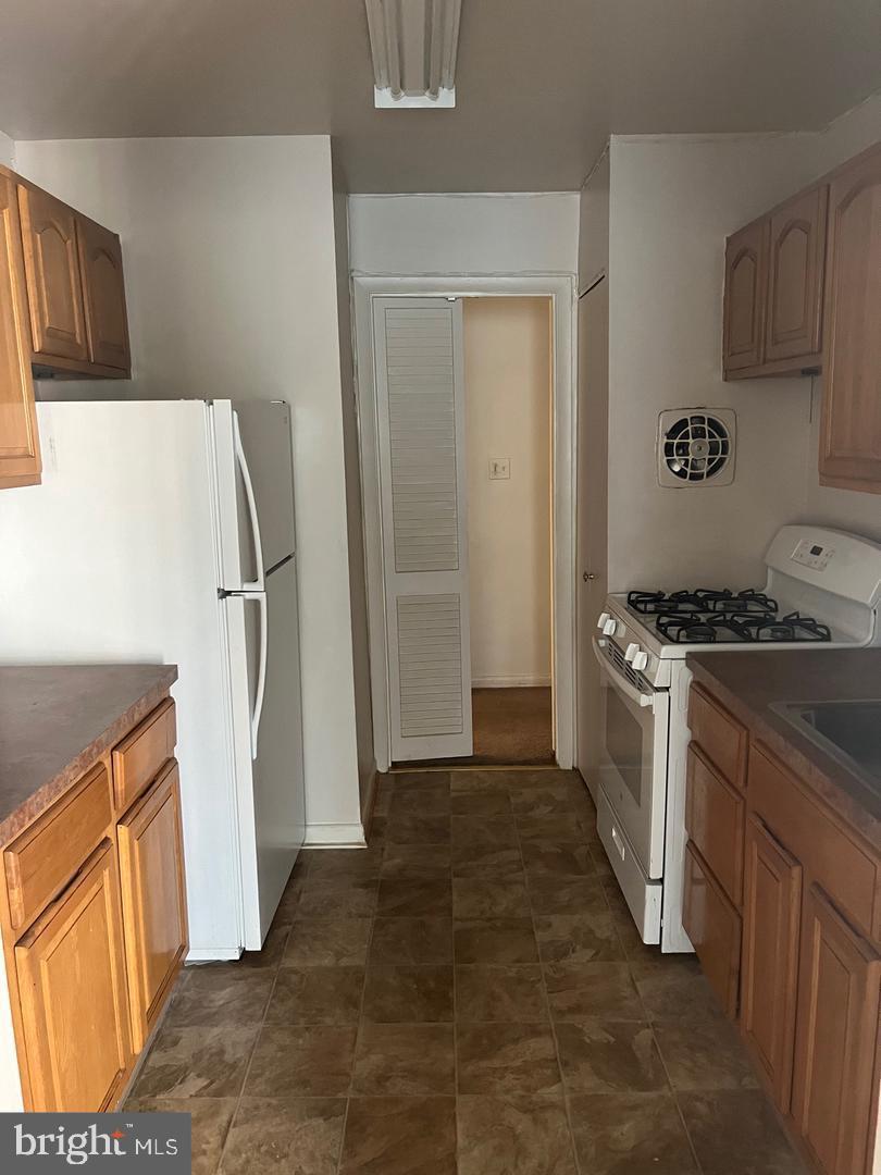 3827 St Barnabas Road, Unit 3831T Suitland, MD 20746 - Photo 7 of 11 a kitchen with a refrigerator sink stove and cabinets