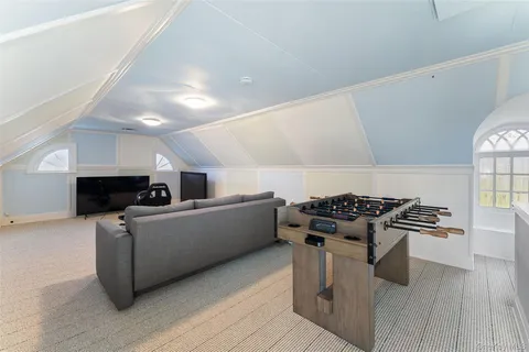 a gym room with furniture and a flat screen tv