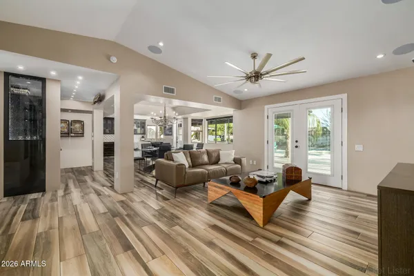 a kitchen with stainless steel appliances granite countertop a refrigerator a sink dishwasher a stove and a dining table with wooden floor