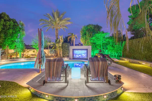 a view of a patio with couches table and chairs with potted plants and big yard