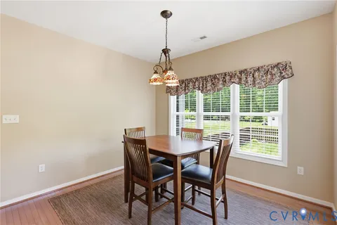 a dining room with a wooden table and chairs