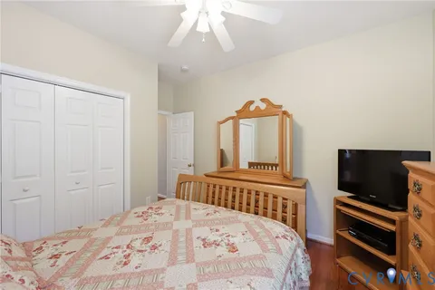 a bedroom with a bed and a flat tv screen on dresser