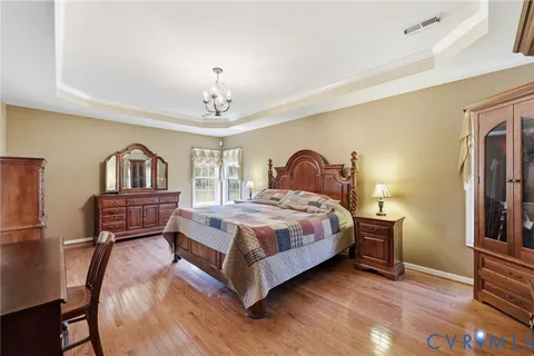 a bedroom with a bed wooden floor and window