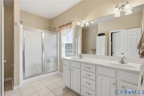 a bathroom with a double vanity sink mirror and a shower
