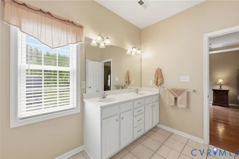 a spacious bathroom with a double vanity sink a mirror and a shower