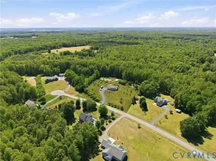 an aerial view of a house with a yard and lake view