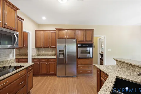 a kitchen with stainless steel appliances granite countertop a refrigerator stove and oven