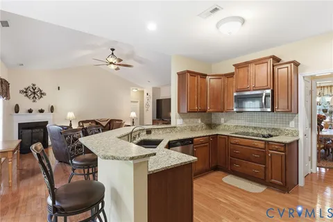 a kitchen with a stove a sink a dining table and chairs