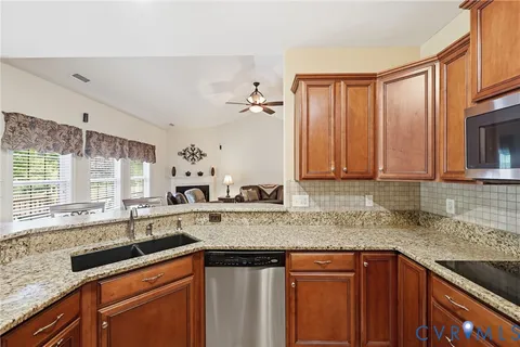 a kitchen with stainless steel appliances granite countertop a sink stove and cabinets