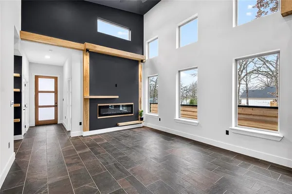 a view of an empty room with a fireplace and a window