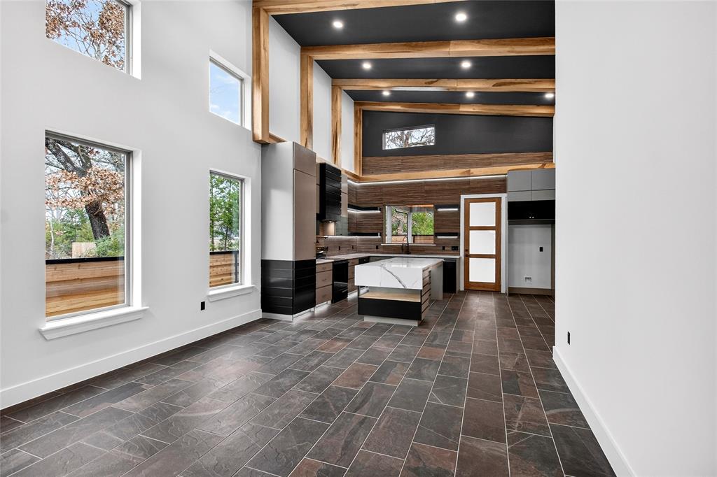 124 Aztec Drive Mabank, TX 75156 - Photo 10 of 33 Unfurnished living room with vaulted ceiling, recessed lighting, and dark stone finish floors