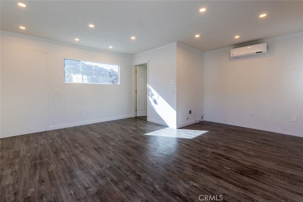 7157 Foothill Boulevard Tujunga, CA 91042 - Photo 16 of 20 a view of an empty room with wooden floor and a window