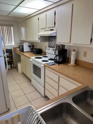 a bathroom with a granite countertop bathtub shower sink vanity and toilet