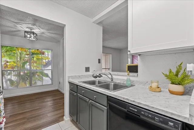 a kitchen with a sink and wooden floor