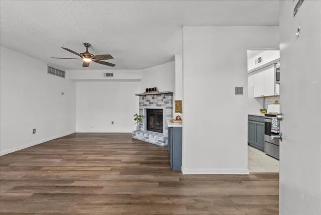 a view of a livingroom with wooden floor and a ceiling fan