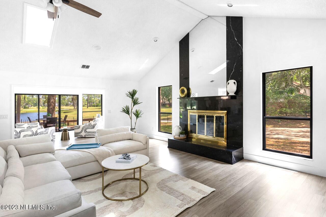 a living room with fireplace furniture and a large window