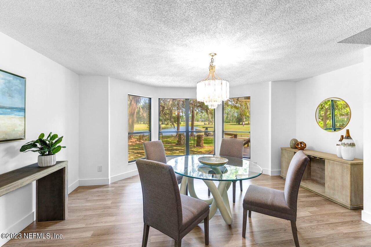4309 Monument Road Jacksonville, FL 32225 - Photo 19 of 65 a view of a dining room with furniture a chandelier and wooden floor