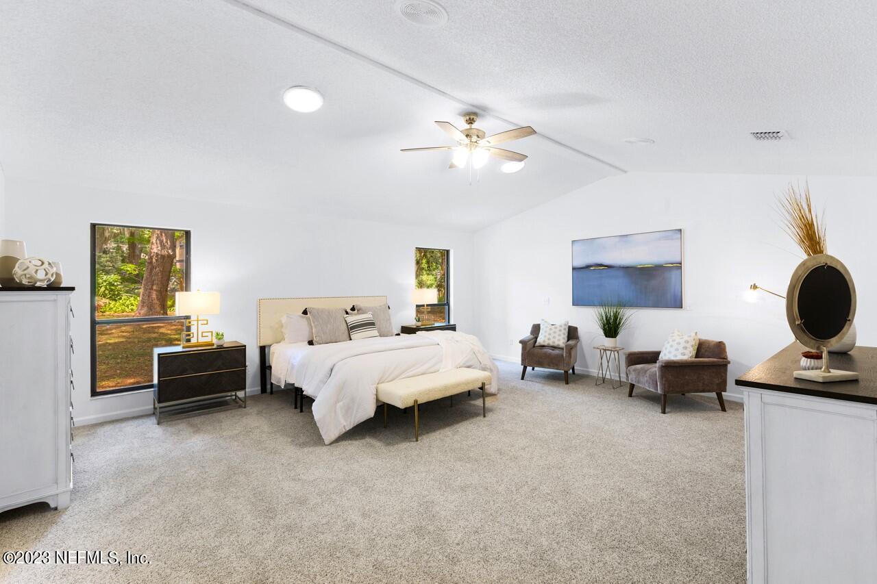 4309 Monument Road Jacksonville, FL 32225 - Photo 35 of 65 a spacious bedroom with a bed and lamp