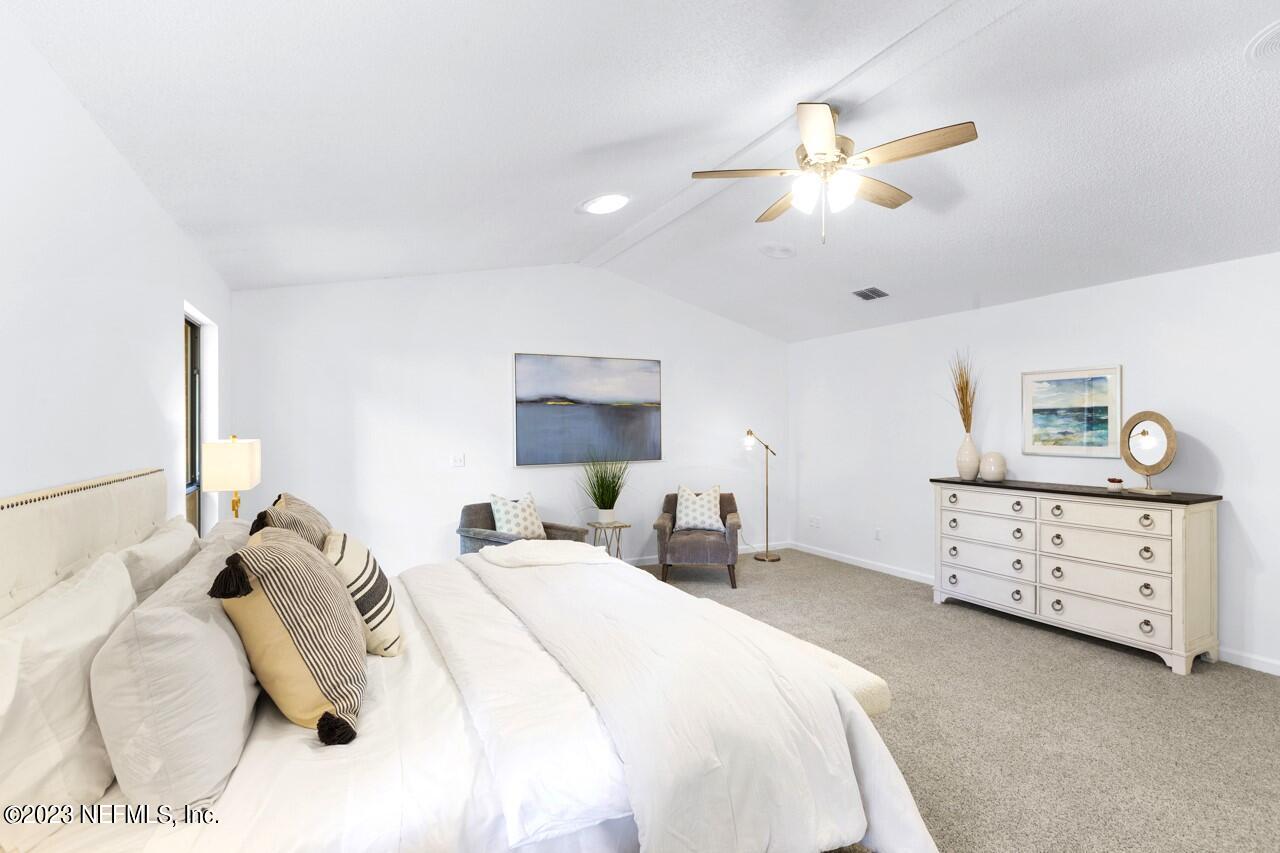 4309 Monument Road Jacksonville, FL 32225 - Photo 36 of 65 a bedroom with a bed and a chandelier