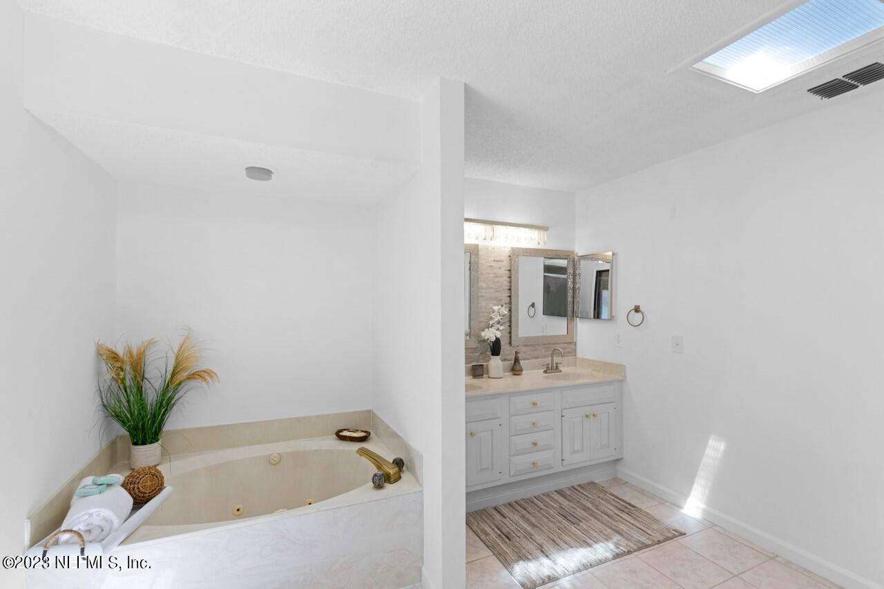 4309 Monument Road Jacksonville, FL 32225 - Photo 41 of 65 a bathroom with a tub sink and mirror