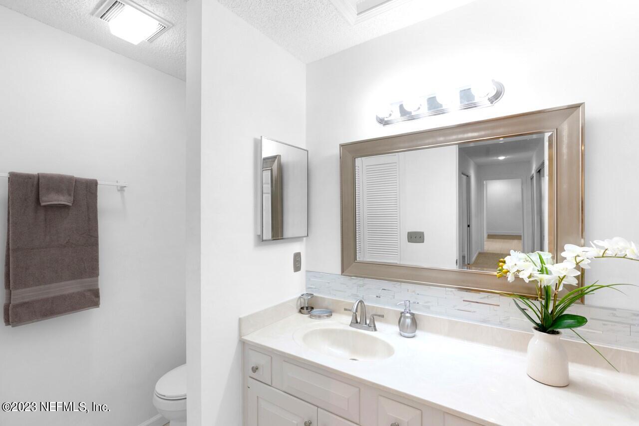 4309 Monument Road Jacksonville, FL 32225 - Photo 48 of 65 a bathroom with a sink a toilet and a mirror