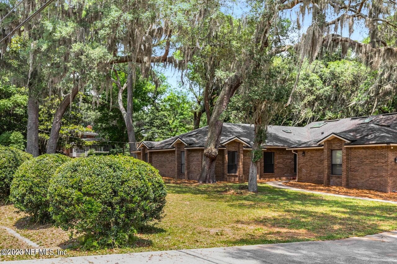 4309 Monument Road Jacksonville, FL 32225 - Photo 54 of 65 a view of a white house with a large tree and a yard with plants