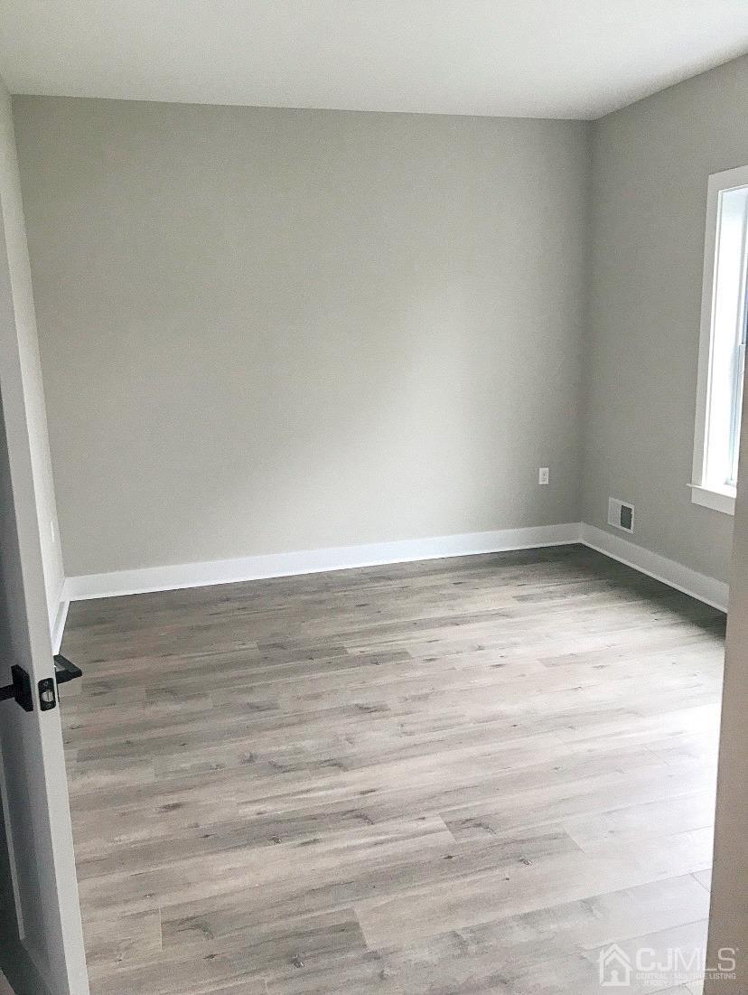 233 Privateer Road Manahawkin, NJ 08050 - Photo 14 of 47 a view of an empty room with wooden floor and a window