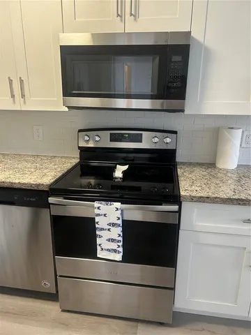 a stove top oven sitting inside of a kitchen