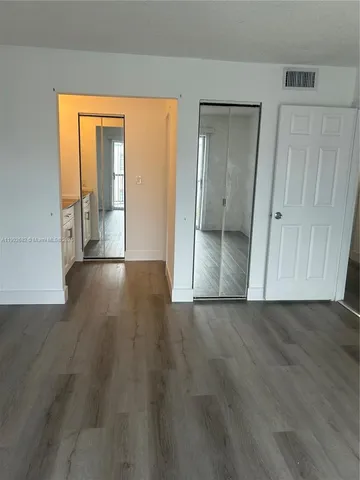 an empty room with wooden floor and a door