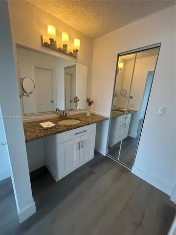 a bathroom with a sink a mirror and a vanity
