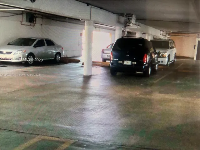 a view of parking garage with cars parked