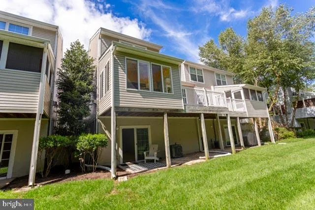 a view of a house with a yard and a large tree