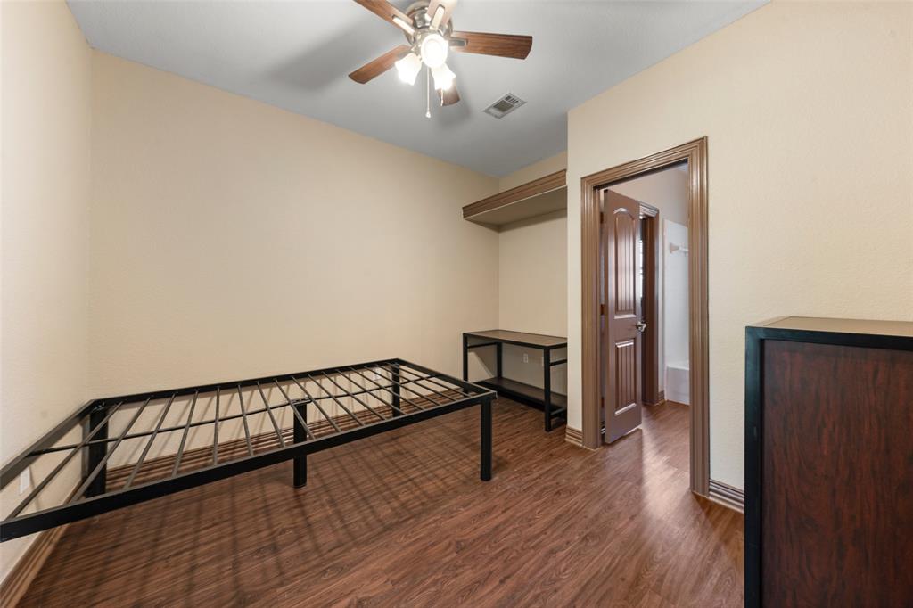 2410 South 2nd Street, Unit 1053 Waco, TX 76706 - Photo 12 of 27 Unfurnished bedroom featuring dark wood-style flooring and a ceiling fan