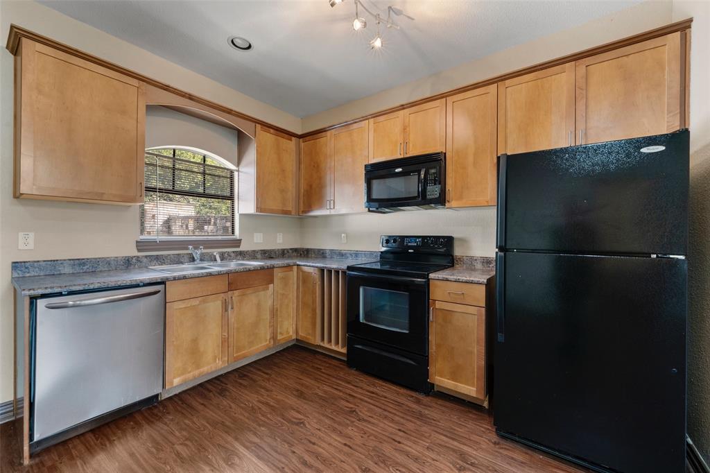 2410 South 2nd Street, Unit 1053 Waco, TX 76706 - Photo 6 of 27 Kitchen with black appliances, dark wood-type flooring, and dark countertops