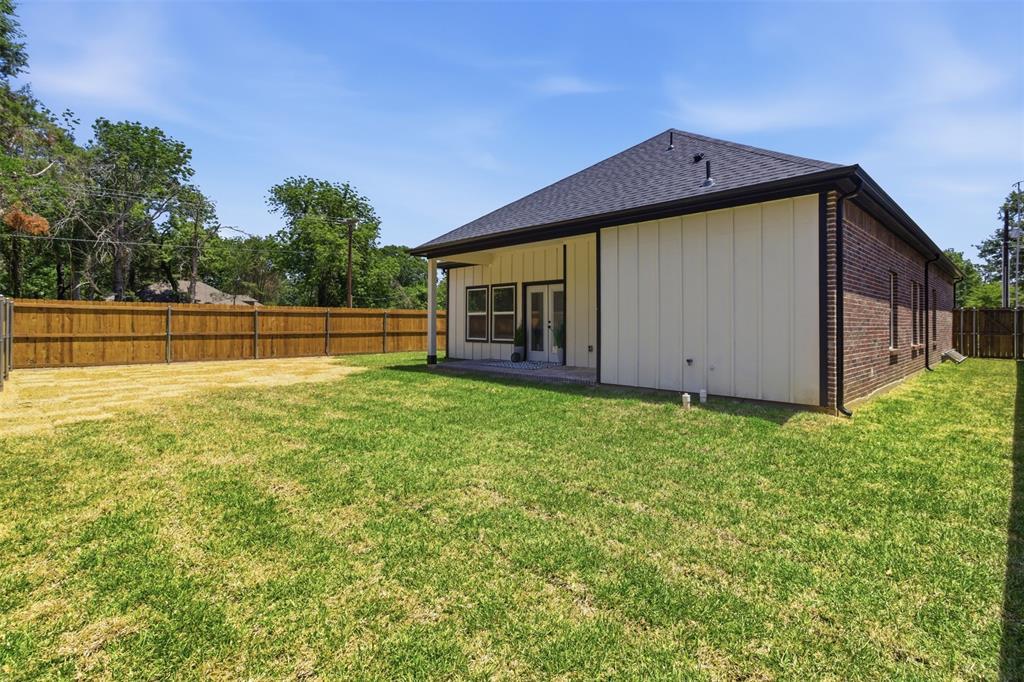435 Waterboard Road Trinidad, TX 75163 - Photo 38 of 39 Spacious backyard featuring a full privacy fence, covered patio, white vertical siding, and brick exterior