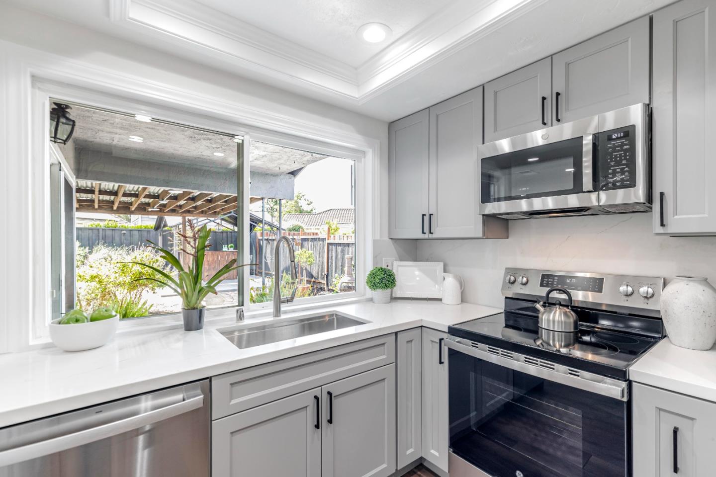 169 Turquoise Way Livermore, CA 94550 - Photo 14 of 59 a kitchen with stainless steel appliances granite countertop a sink a stove and a microwave