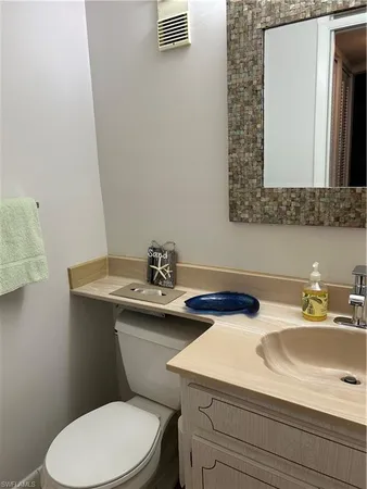 a bathroom with a sink a toilet and mirror