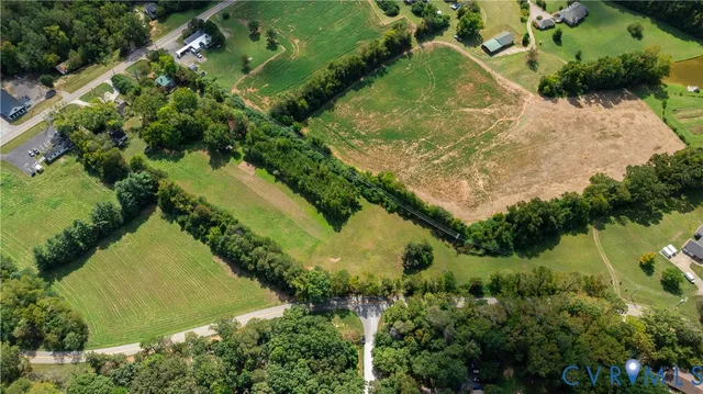 an aerial view of residential houses with outdoor space and trees all around
