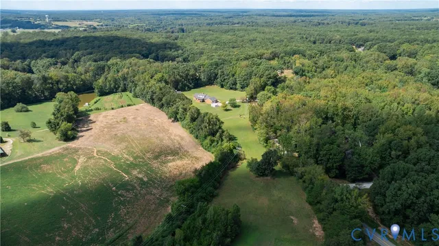 an aerial view of residential houses with outdoor space and trees