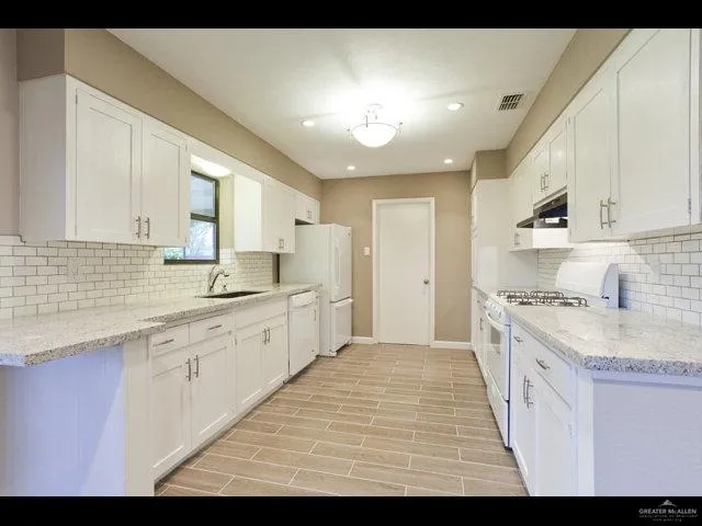 a large kitchen with kitchen island a sink stainless steel appliances and cabinets