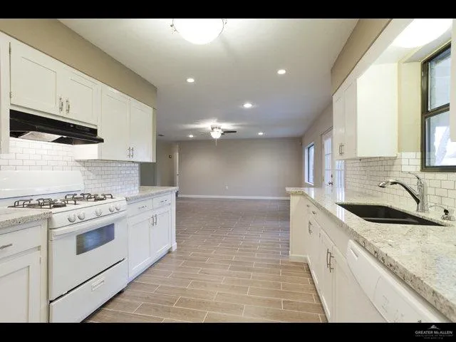 a kitchen with a sink stove top oven and cabinets